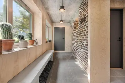 a hallway with a bench and a brick wall at Spectacular Fjord getaway - The Forge in Leirgulen