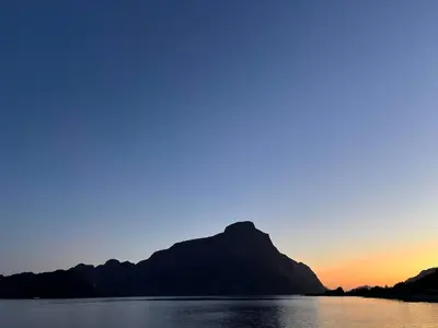 a mountain in the middle of a lake at sunset at Spectacular Fjord getaway - The Forge in Leirgulen