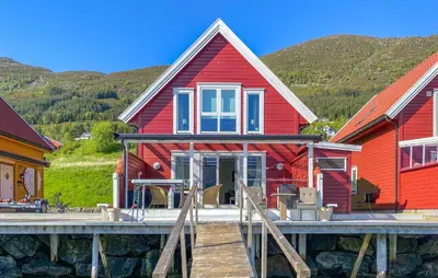 a red house with a dock in front of it at 3 Bedroom Awesome Home In Gursken in Larsnes