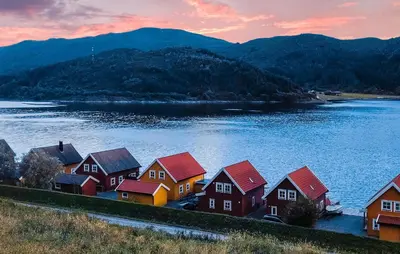 a group of houses on the shore of a lake at 3 Bedroom Awesome Home In Gursken in Larsnes