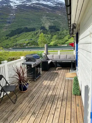 a deck with a grill and a barbecue on a house at Sea Front Olden in Olden