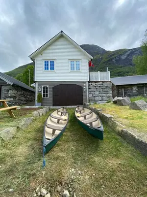two canoes sitting on the grass in front of a house at Sea Front Olden in Olden