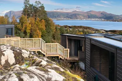 a house on a hill with a view of the water at Torvika Seaview Pods in Bølandet