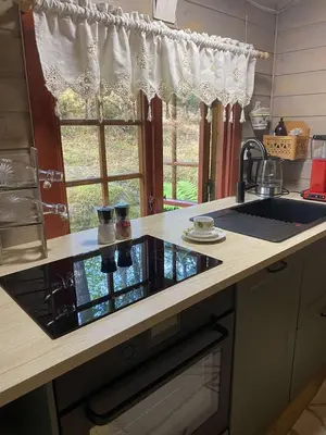 a kitchen counter with a sink and a window at Skogshytte in Holmøyane