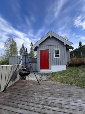 a small house with a red door on a deck at Cozy chair in Jølster in Skei