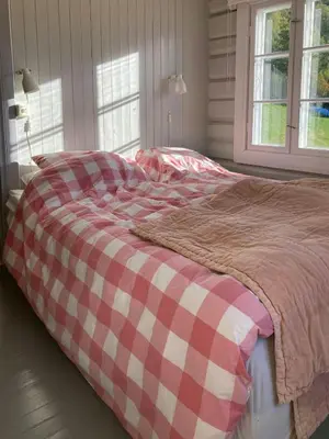 a large bed with a red and white checkered blanket at Farm In The Heart Of Gudbrandsdalen in Kvam