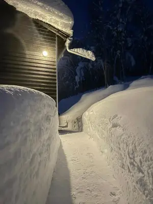 a pile of snow in front of a house with a light at Unique, Modern Cabin With A Stunning View in Sogndal