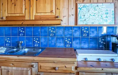a kitchen with a sink and a blue tiled wall at Gorgeous Home In Vøringsfoss With Sauna in Maurset