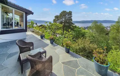 a patio with three chairs and a table on a house at Nice Apartment In Bergen With Wifi in Bergen