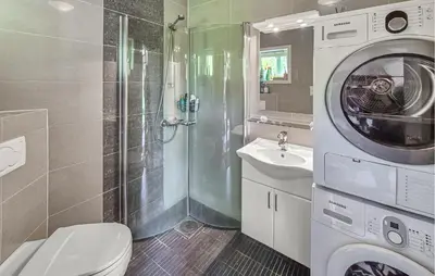 a bathroom with a washing machine and a sink at Nice Apartment In Bergen With Wifi in Bergen