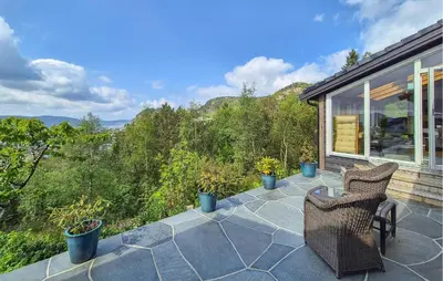 a patio with two chairs and plants on a house at Nice Apartment In Bergen With Wifi in Bergen