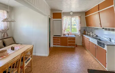 a kitchen with brown cabinets and a counter top at Lovely Apartment In Lillehammer in Lillehammer