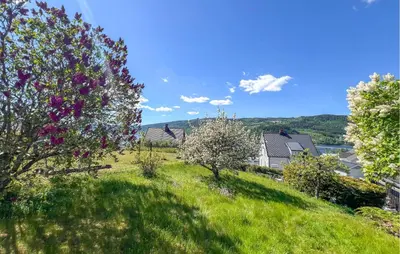a grassy hill with trees and houses in the background at Lovely Apartment In Lillehammer in Lillehammer