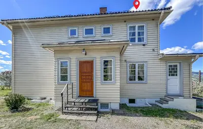 a white house with a red door at 2 Bedroom Nice Apartment In Lillehammer in Lillehammer