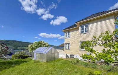a greenhouse in a yard next to a house at 2 Bedroom Nice Apartment In Lillehammer in Lillehammer