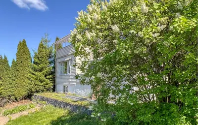 a gray house with trees in front of it at 2 Bedroom Nice Apartment In Lillehammer in Lillehammer