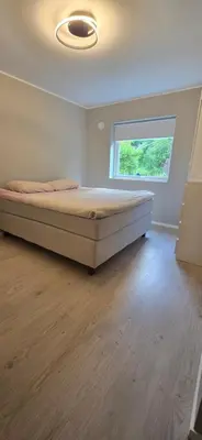 a bedroom with a bed in a room with a window at Modern house in Bergen