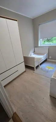 a white bedroom with a bed and a window at Modern house in Bergen