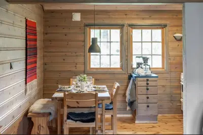 a dining room with a table in a wooden house at Guest favorite - 5 mins from Vøringsfossen in Garden
