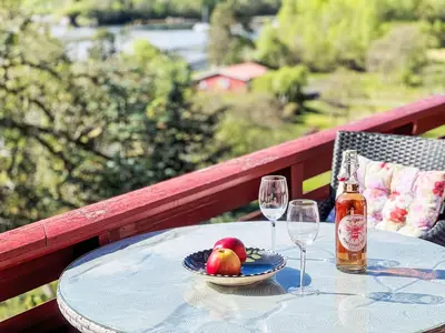 a table with a bowl of fruit and two wine glasses at Holiday Home Tussebu by Interhome in Gripne