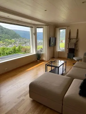 a living room with a couch and a large window at Stryn Central View in Stryn