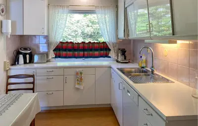 a kitchen with white cabinets and a sink and a window at Stunning Apartment In Selje With Wifi in Selje