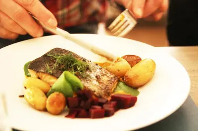 a plate of food with meat and vegetables on a table at Haukeli Hotel in Haukeligrend