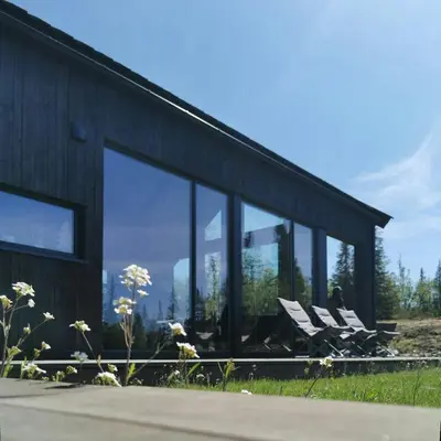 a couple of white chairs in front of a building at Family Cabin With Annexe In Haglebu in Eggedal
