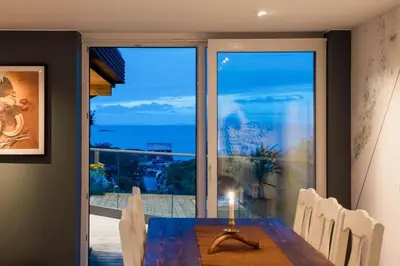 a dining room with a table and a view of the ocean at Kvitsand Ocean Castle in Hitra