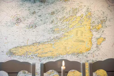 a map on a wall with two candles in front of it at Kvitsand Ocean Castle in Hitra