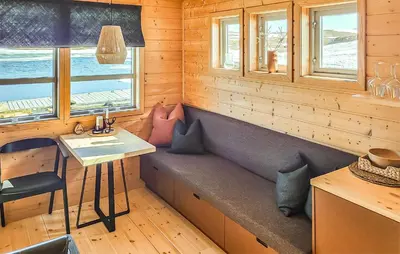 a bench in a cabin with a table and windows at Lovely Home In Vøringsfoss With Sauna in Maurset