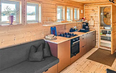 a kitchen with a bench in a wooden cabin at Lovely Home In Vøringsfoss With Sauna in Maurset