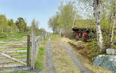 a dirt road next to a fence and a cabin at 2 Bedroom Lovely Home In Oppdal in Oppdal