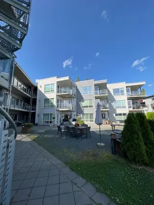 a large apartment building with a patio and an umbrella at Staupslia Apartment in Levanger