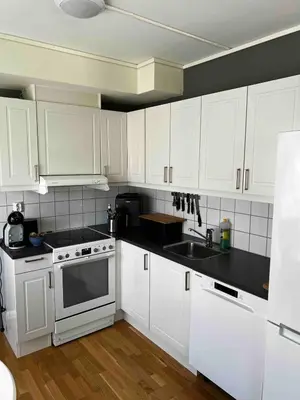 a kitchen with white cabinets and a sink at Staupslia Apartment in Levanger