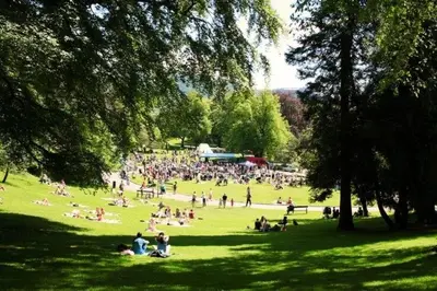 a large group of people sitting in a park at Hyggehuset in Bergen