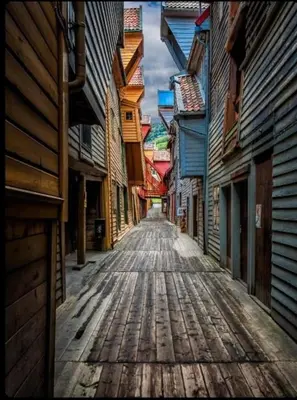 an empty street in an alley between buildings at Hyggehuset in Bergen