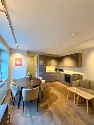 a kitchen and living room with a table and chairs at Central apartment in Bergen