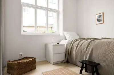 a white bedroom with a bed and a window at Sentral leilighet, Bergen in Bergen
