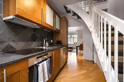 a kitchen with a sink and a staircase at Bright Top-Floor Apartment with Sea View in Bergen