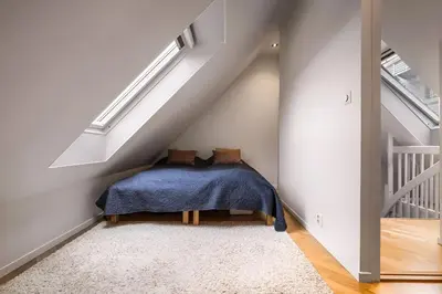 a room with a blue blanket sitting under the stairs at Bright Top-Floor Apartment with Sea View in Bergen
