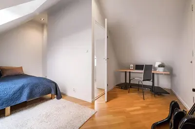 a bedroom with a bed and a desk with a table at Bright Top-Floor Apartment with Sea View in Bergen