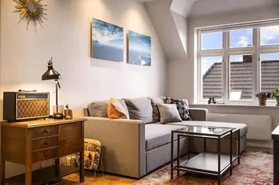 a living room with a couch and a table at Bright Top-Floor Apartment with Sea View in Bergen