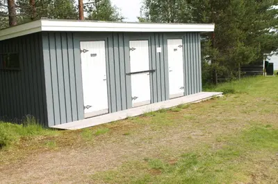 a green shed with four doors on a field at Feriested i Tørberget in Tørberget