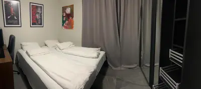 a bed with white sheets and pillows in a room at Husafjellet in Ålesund