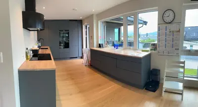 a kitchen with a counter and a clock on the wall at Husafjellet in Ålesund