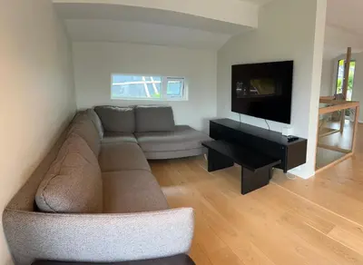 a living room with a couch and a flat screen tv at Husafjellet in Ålesund