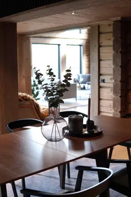 a wooden table with a vase with flowers on it at Exclusive Fjord Lodge with Private Jacuzzi and Epic Views in Lii