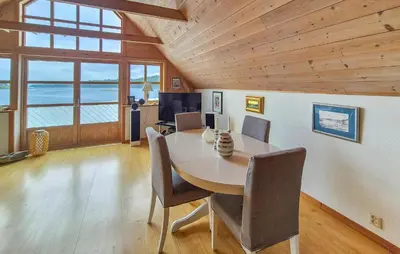 a dining room with a table and chairs at Nice Home In Manger With House Sea View in Manger