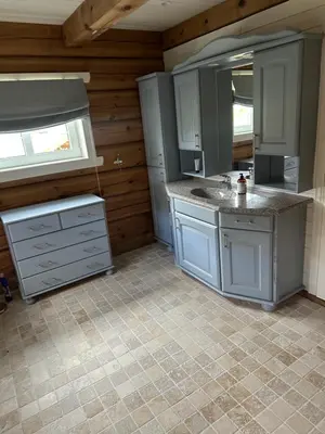 a kitchen with white cabinets and a sink and a window at Lekker tømmerhytte in Tyinkrysset